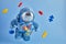 Autism awareness background. Blue plush astronaut toy with puzzle heart, autism symbol, on blue background