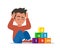 Autism concept. Boy feeling lonely. Sad boy sitting on floor surrounded by cubes toys with word autism. Child plugged ears with