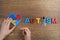 Autistic boy hands holding heart shapeed puzzle with word autism and awarennes ribbon on wooden background. Autism