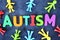 Autistic child concept with colorful plastic letter spelling autism on dark background