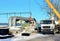 Auto crane lifling truck with concrete slabs on construction site Construction worker navigating with concrete slab lifted by