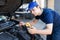 Auto electrician working on a car engine