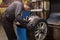 Auto mechanic balancing car tire at workshop