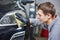 Auto mechanic buffing and polishing car headlight