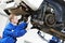 Auto mechanic at car suspension repair work