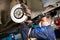 Auto mechanic at car suspension repair work