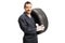 Auto mechanic carrying a car tire and smiling at the camera