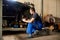 Auto mechanic in dirty work uniform repairs front wheel car