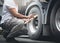 Auto Mechanic Driver Holding Clipboard is Checking A Truck Wheels and Tires. Inspection Maintenance and Safety of Semi Truck.