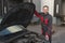 Auto mechanic expert stands at car with opened hood. Used car specialist