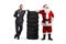 Auto mechanic holding a wrench and Santa Claus posing with a pile of tires