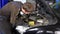 Auto mechanic man removing dirty air filter in near cars engine