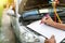 Auto mechanic perform vehicle checkup while service advisor take notes,Professional