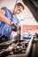 Auto mechanic repairer changing spark plugs on the car