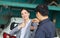 Auto mechanic repairman handing car remote key to client, Mechanic returns the key to the satisfied custumer, Car repair and