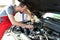 Auto mechanic repairs vehicle in a workshop