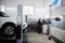 Auto mechanic sets american SUV car for diagnostics and configuration camber check in workshop of service station