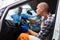 Auto mechanic sitting in broken car and listens to engine operation