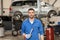 Auto mechanic or smith with wrench at car workshop