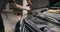 Auto mechanic unscrewing front headlight close up car repair in garage