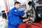 Auto mechanic at wheel alignment work with spanner