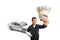 Auto mechanic worker holding stacks of money in front of a silver car