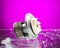 Auto parts, engine cooling pump in spurts of water on purple background.