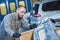 Auto repairman worker with protecting paper in garage workshop