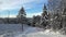 Auto road near forest with ski track in winter