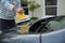 Auto service staff cleaning a car bonnet with rotating wash brush