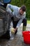 Auto service staff washing a car tyre with sponge