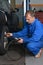 Auto Service Technician Checking Tire Pressure