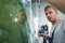 Auto service technician man wetting protective film closeup