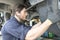 Auto services and Car repairs. A male mechanic inspecting on a car in an auto repair shop