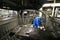 An auto worker working on the body work of an unpainted vehicle.