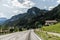 Autobahn or highway with a bridge in the mountains with clear marking surrounded by vibrant green trees under blue sky. Mountain