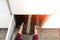 Automated locker. Parcel courier box in woman hands at post delivery automat terminal. Courier Puts Cardboard Package