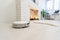 Automated vacuum cleaning robot powered by rechargeable battery in modern living room