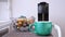 Automatic capsular coffee machine or coffeemaker pouring espresso coffee at home in a mint color cup