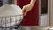 Automatic dishwashing machine at home. Close-up woman's hand take shiny clean plates from opened dishwasher