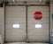 Automatic gates inside industrial storage warehouse with red stop sign