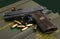 Automatic hand gun and ammunition on green bullet box background