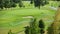 Automatic high-pressure water sprinkler at green golf course watering the grass.