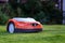 Automatic lawn robot mower moves on the short cut grass, lawn. Close up side view with blurry background