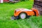 Automatic lawn robot mower under rain at charging stations on the grass, lawn. Close up side view with blurry background