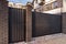 Automatic metal gates with decorative brick columns on the street side.