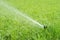 Automatic smart lawn sprinkler with adjustable head watering green lawn grass in sunny day