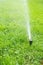 Automatic smart lawn sprinkler with adjustable head watering green lawn grass in sunny day