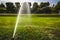 automatic sprinkler system watering the lawn on a background of green grass. Garden irrigation system watering lawn on a sunny