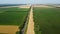 Automobile asphalt road with cars driving along it between agricultural fields